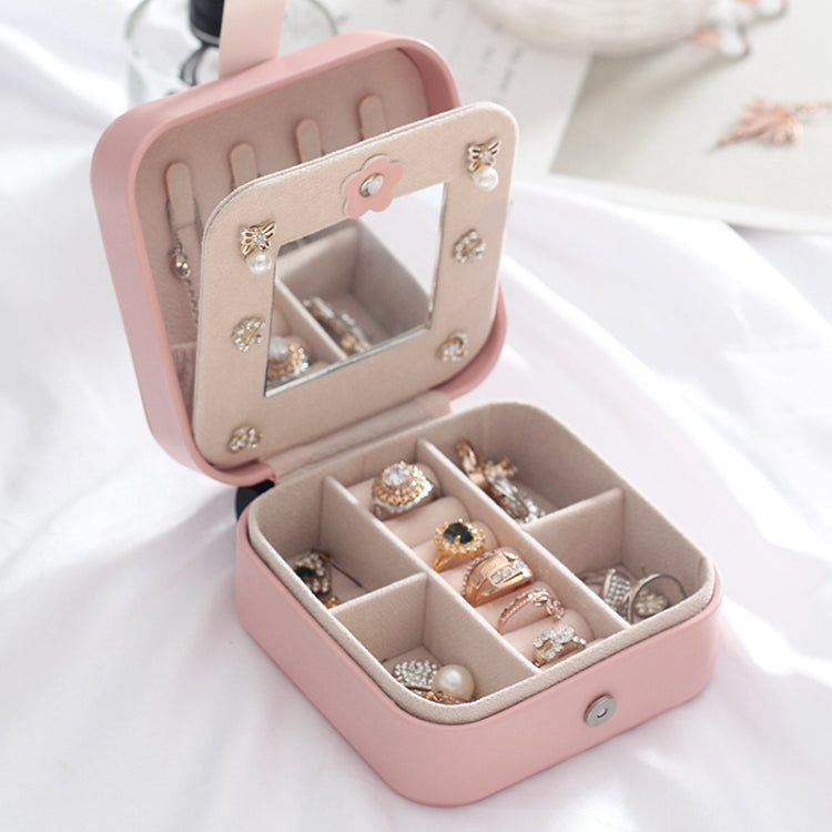 Pink leather jewelry box open with hinged mirror panel and four ring compartments