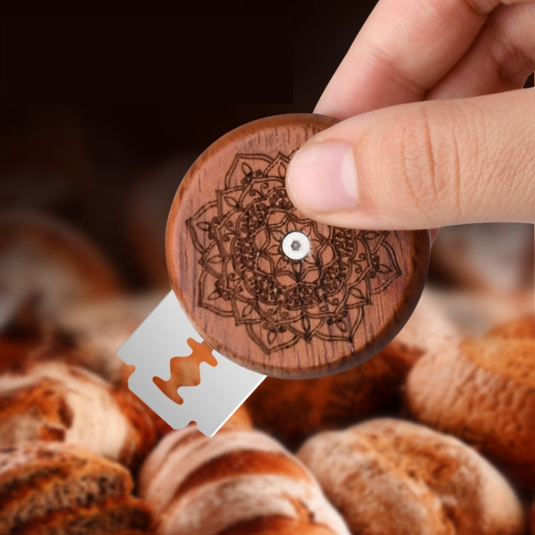 Etched wooden bread trimming knife disk with metal center, blade detail over bread