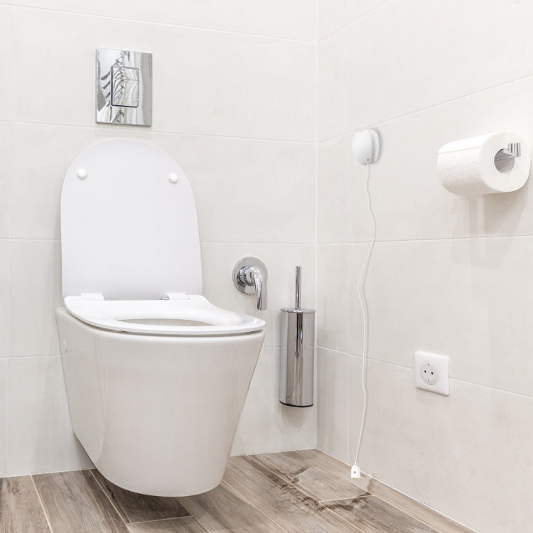 Wall-mounted Wi-Fi water leak sensor alarm with white housing near toilet