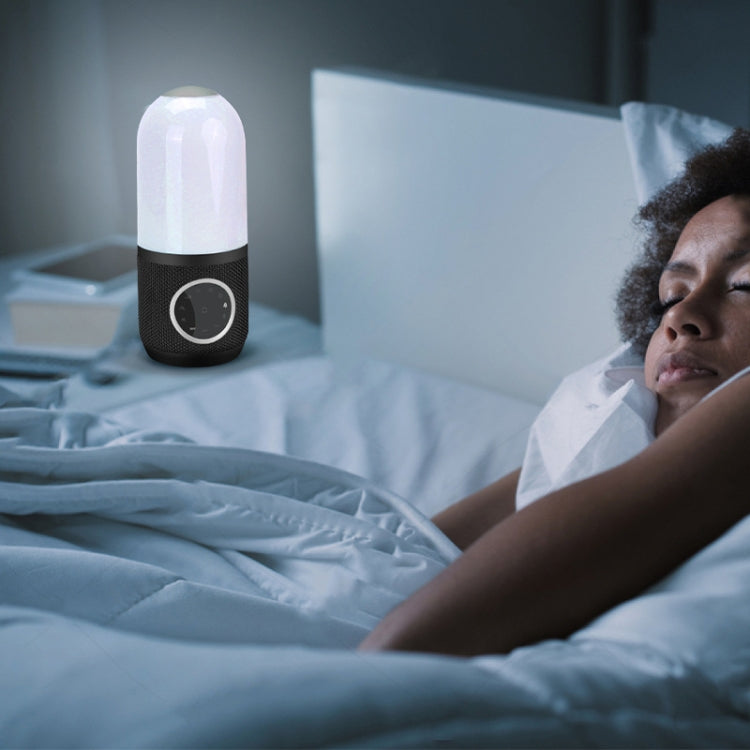 White noise sleep speaker on nightstand next to sleeping person, white dome and black base