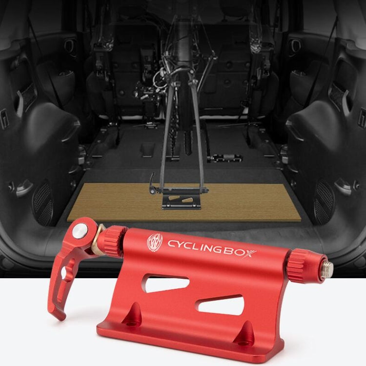 Red aluminum bike fork mount resting on a wooden board for vehicle storage