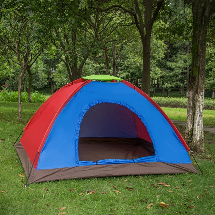 Red and blue single-layer dome tent with open mesh entrance in outdoor grass