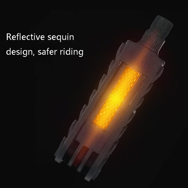 Black folding bicycle pedal with reflective amber strip, angled close-up