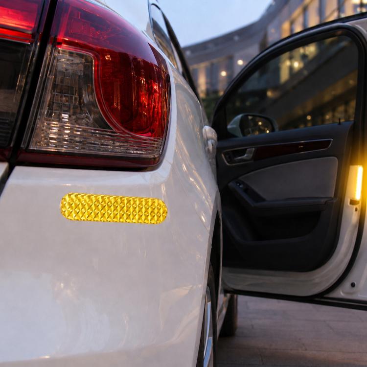 Yellow reflective strip tape decal on car rear panel, bright textured strip near tail light.