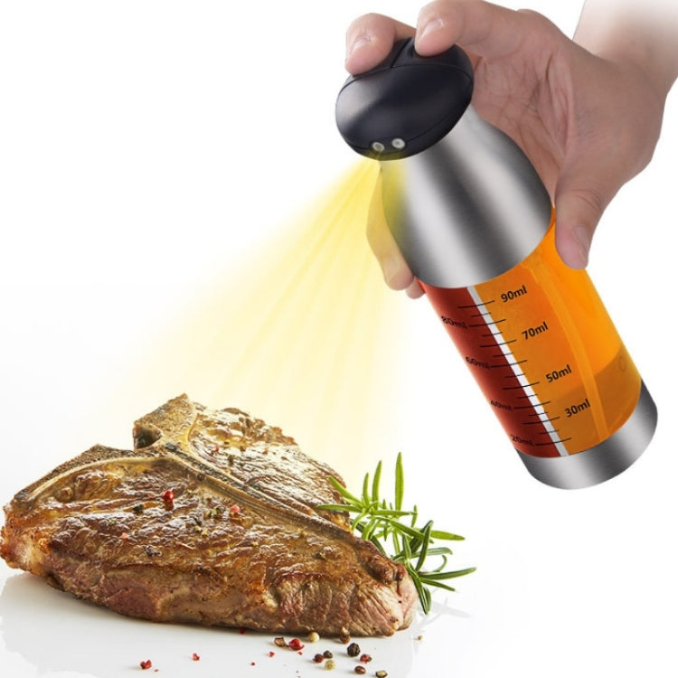 Stainless steel push oil spray bottle spraying oil onto a cooked steak