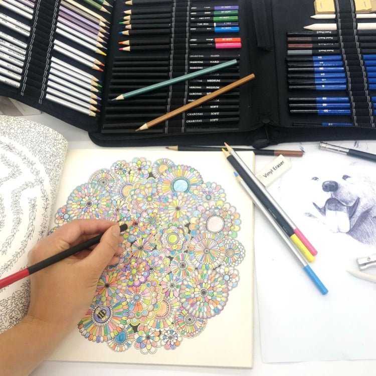 Colored pencil set beside a patterned drawing page with artist’s tools