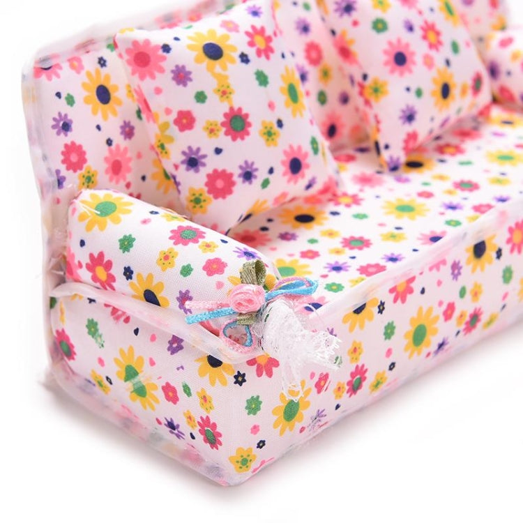 Mini floral fabric dollhouse sofa close-up with tied arm ribbon and two cushions
