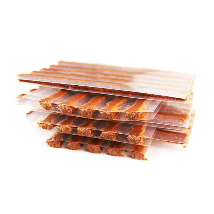 Overlapping clear-backed tire repair strip sheets in brown rubber