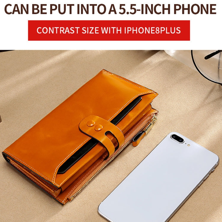 Tan leather long wallet with wrap strap closure and slim front flap.