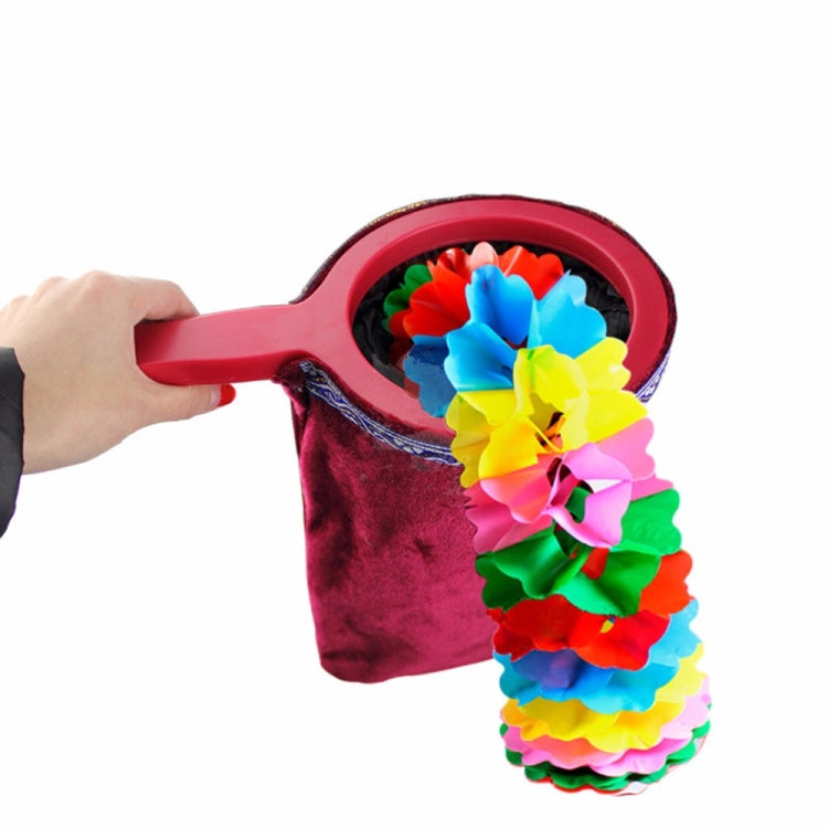 Red velvet magic change bag with pink handle, flowers spilling from opening.