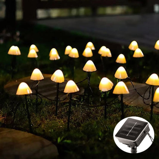 Outdoor solar mushroom string lights with warm white glowing caps on garden stakes
