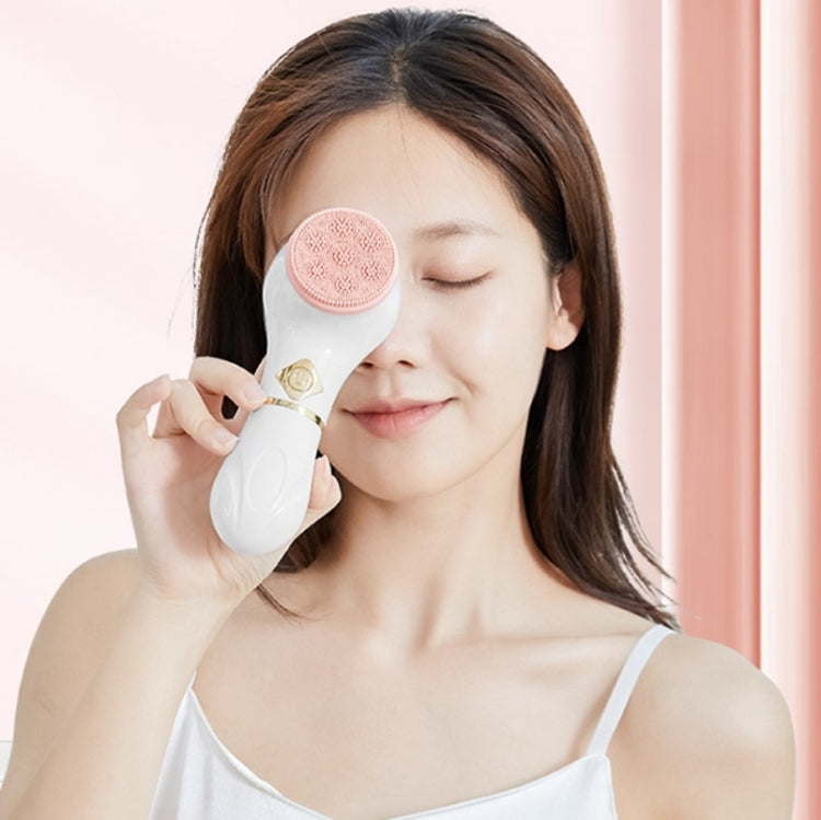 Electric facial cleansing brush used on face with pink silicone cleaning head