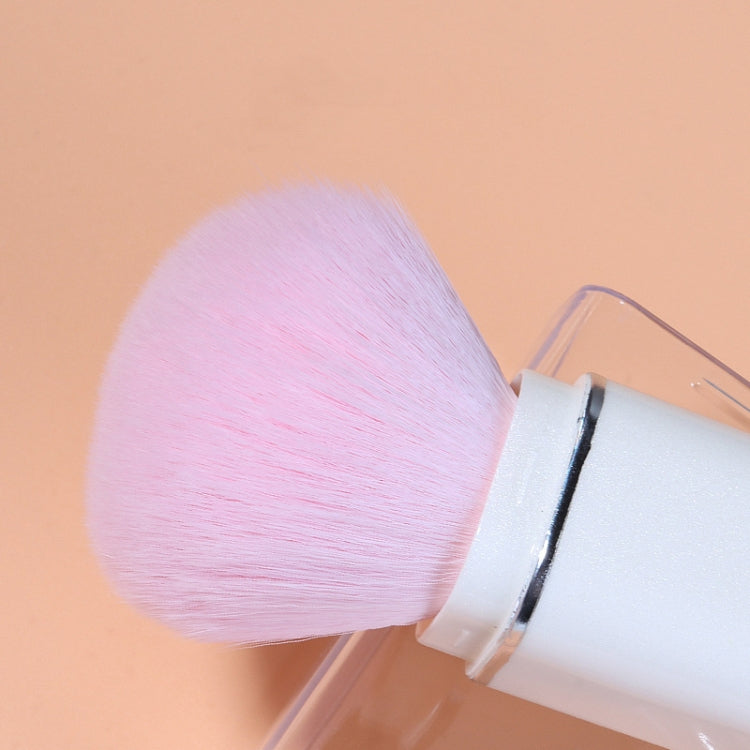 Small powder brush with pink bristles on a white retractable handle