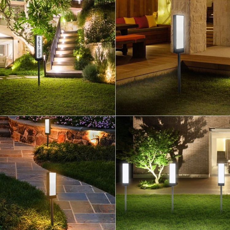 Set of solar house number ground lights with glowing rectangular panels on landscape