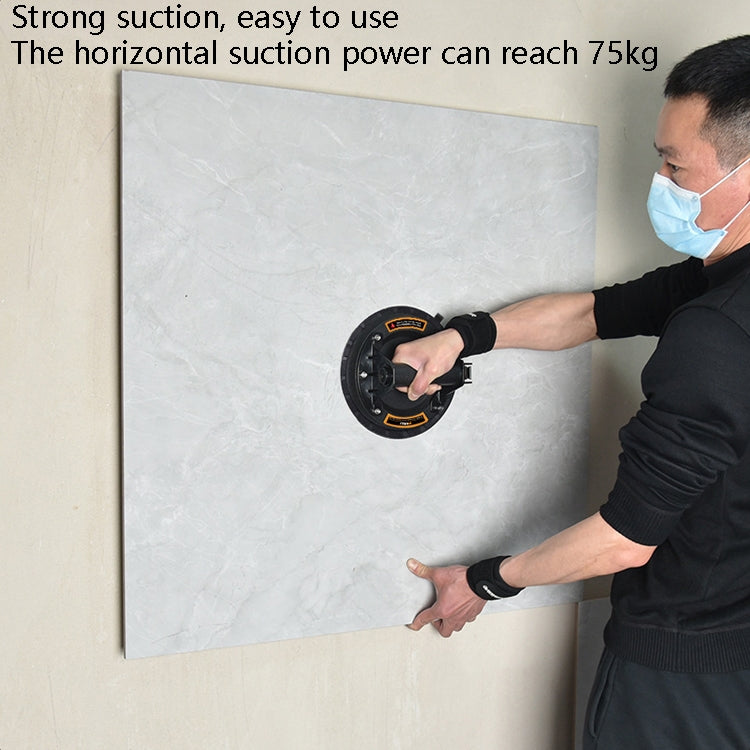 Person using vacuum suction pump on a wall panel with suction cup