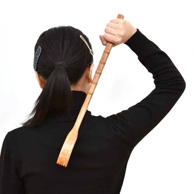 Person using a wooden long-handle back scratcher to scratch the back or scalp