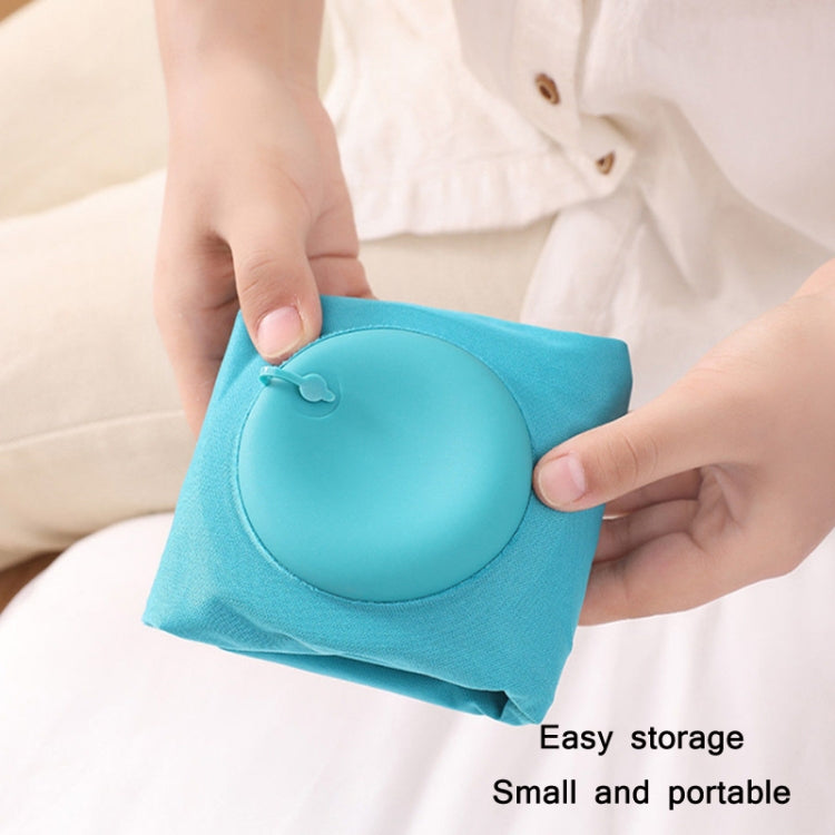 Teal inflatable U-shaped neck pillow being folded for easy storage