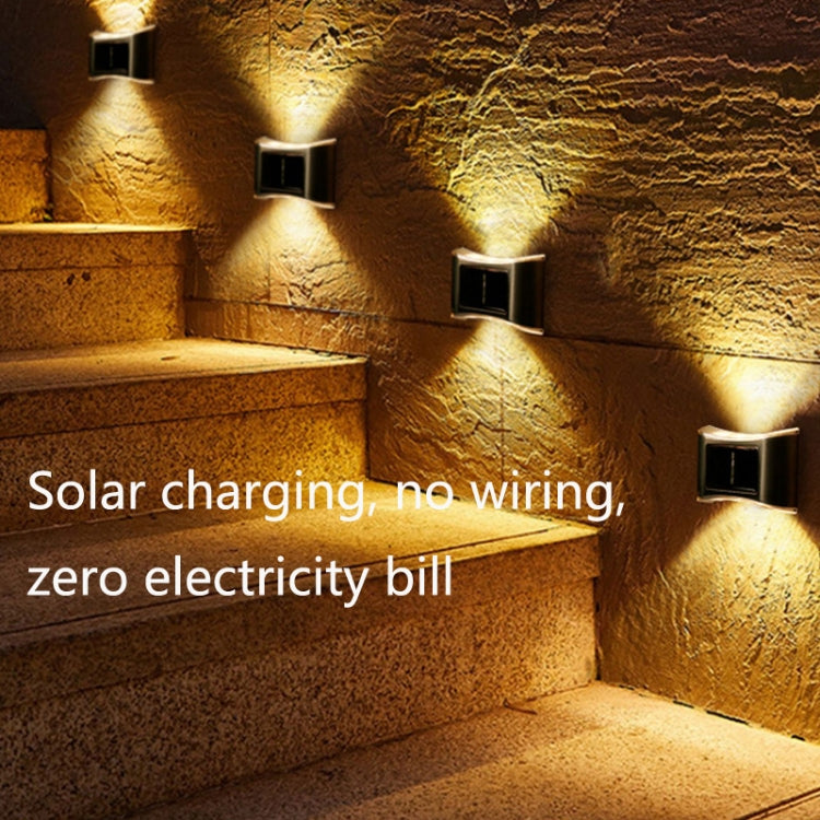 Stainless steel solar wall lamps with warm light along outdoor stone steps