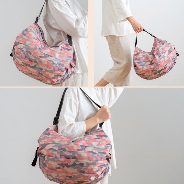 Foldable travel shoulder bag in pink camouflage, carried by hand and on shoulder