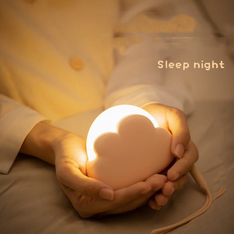 Cloud-shaped USB night light glowing in amber held in hands
