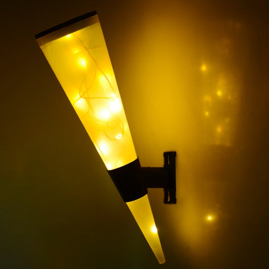 Outdoor solar wall lamp with black mount and clear cone diffuser, glowing warm yellow light.