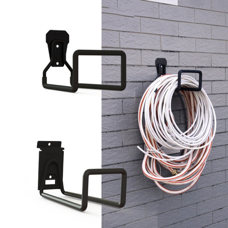 Black garage hook holding bundled white and gray cables on a wall
