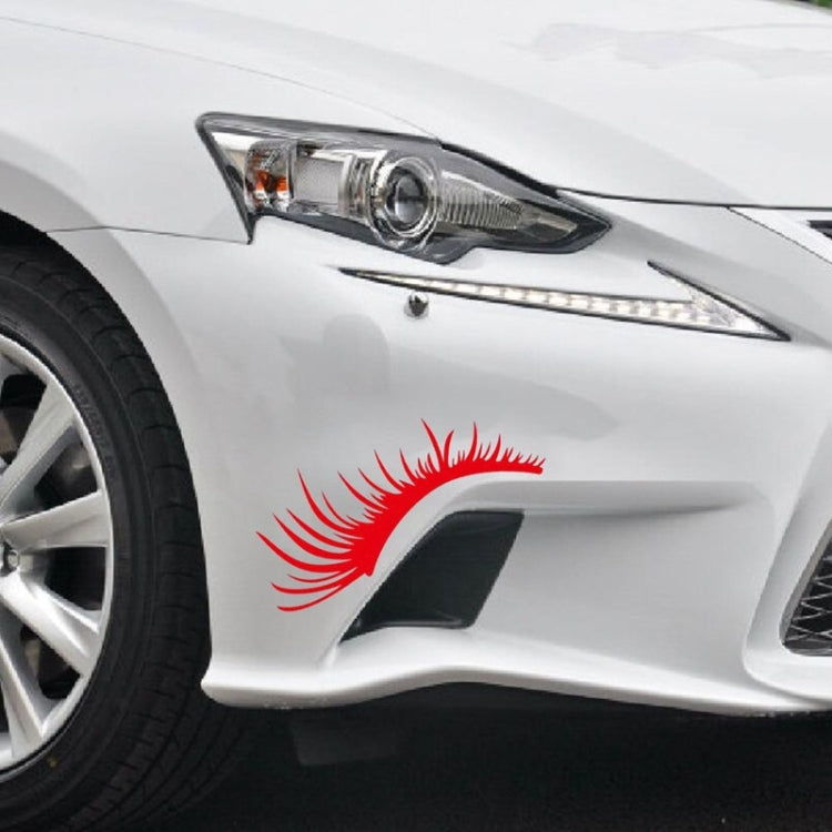 Red eyelash eyebrow headlight sticker on white car front light.