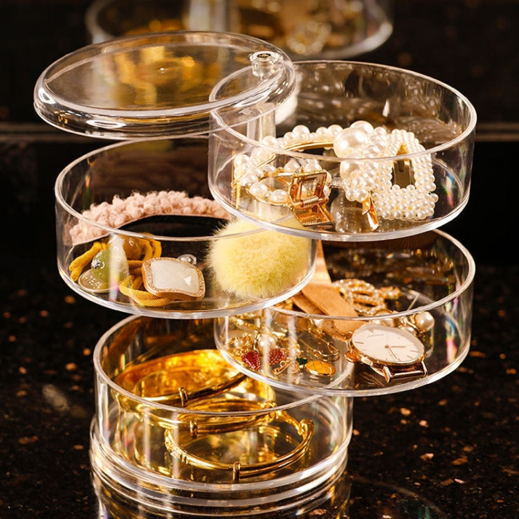 Transparent rotating jewelry organizer with four compartments filled with mixed jewelry