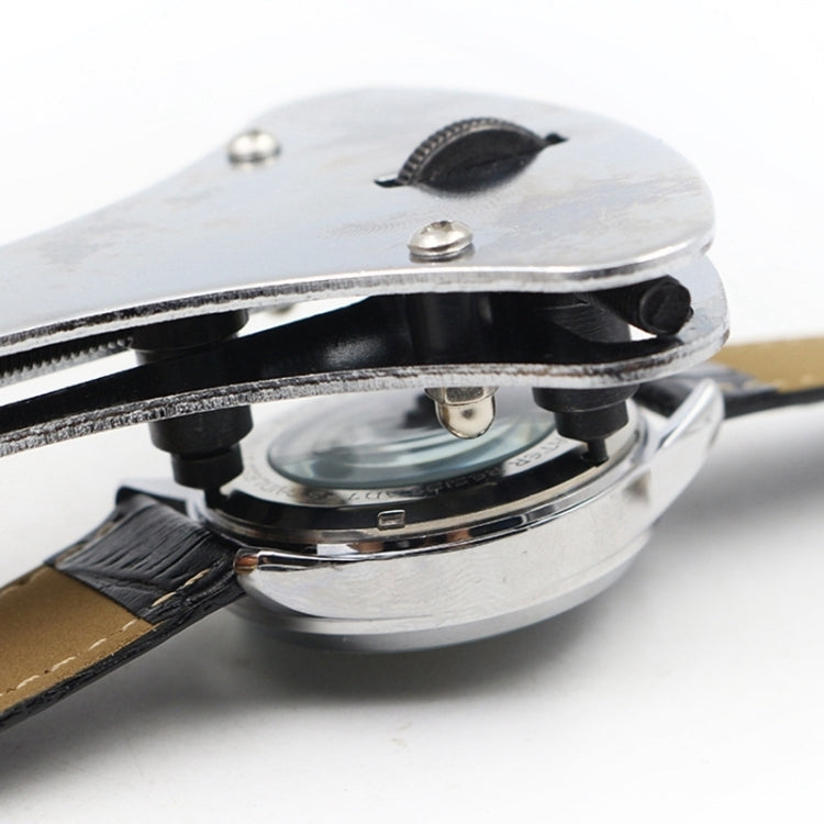 Three-prong watch opener tool head pressing on watch case back
