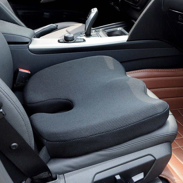 U-shaped car seat cushion installed on a vehicle seat, dark textured fabric and cutout opening