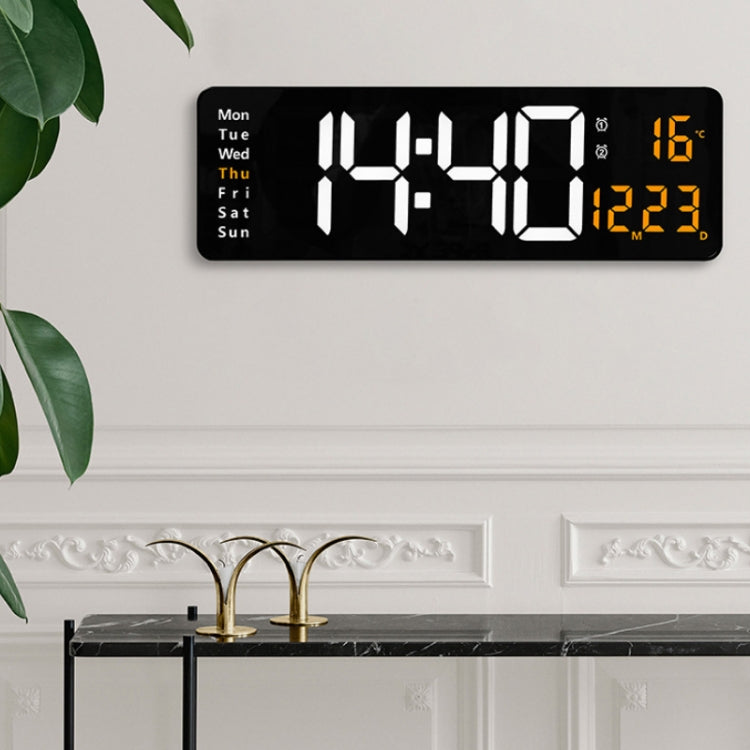 Wall-mounted LED digital clock installed on wall with white time digits and orange temperature