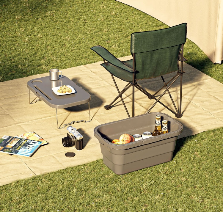 Folding picnic water carrier box on grass with a small tabletop and campsite setup