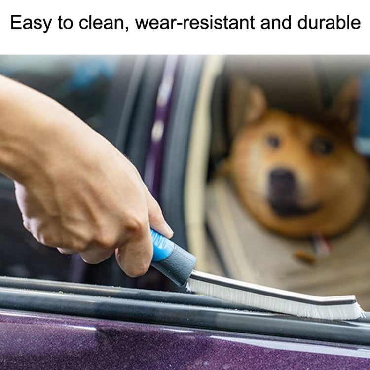 Car crevice cleaning brush with blue handle scrubbing inside door seam