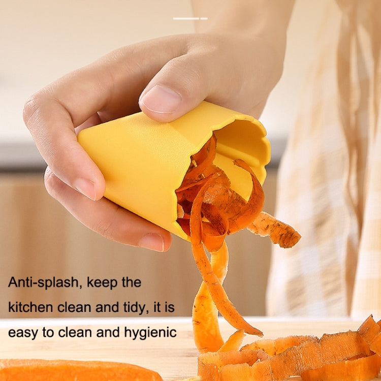 Yellow fruit peeler with stainless blade, cover open as it peels orange skin