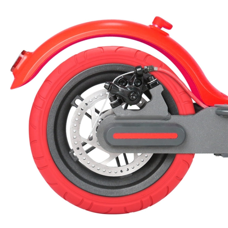Red inflatable solid tire on scooter wheel, brake disc and caliper visible