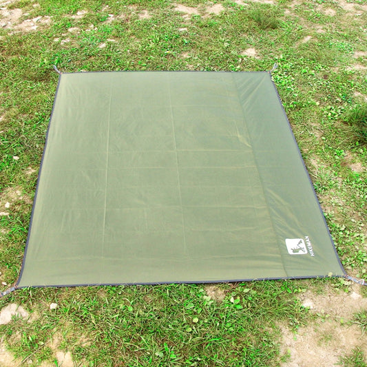 Green waterproof tent ground mat spread flat on grass with corner stakes