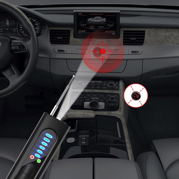 Black handheld detector with blue LED bars placed near car center console
