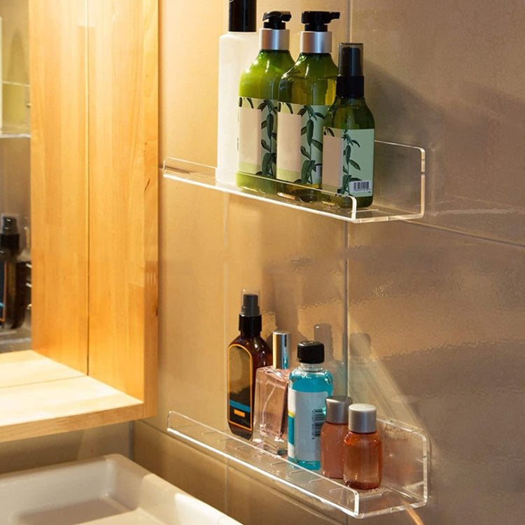 Clear acrylic wall shelf displaying bottles and skincare containers