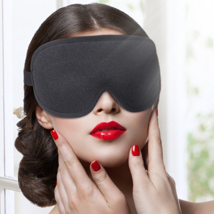 Woman wearing a dark sleep eye mask with contoured nose bridge and side strap.
