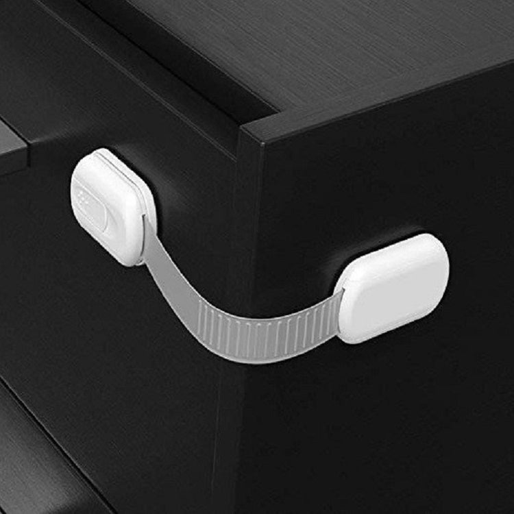 Slide-adjustable drawer safety lock with white housing and gray strap on cabinet