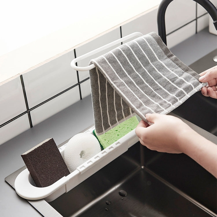 White telescopic sink rack with towel pole holding a striped towel over the sink
