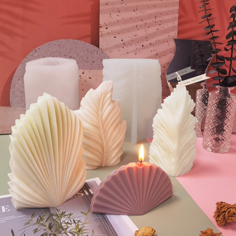 Scalloped silicone mold with leaf-shaped wax candles in cream and pink