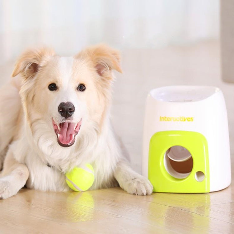 Happy dog next to green-and-white treat machine with tennis ball on the floor