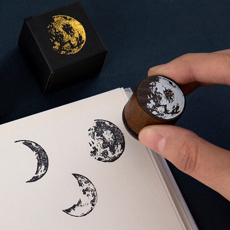 Handheld circular moon phase wooden stamp making white moon prints on paper