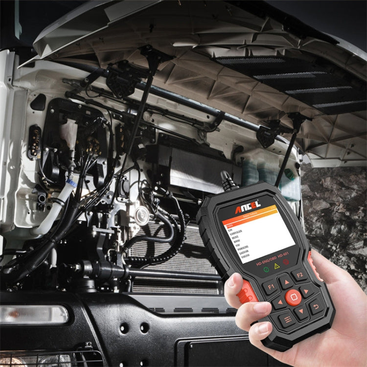 Handheld ANCEL HD601 code reader held near truck engine bay, keypad visible