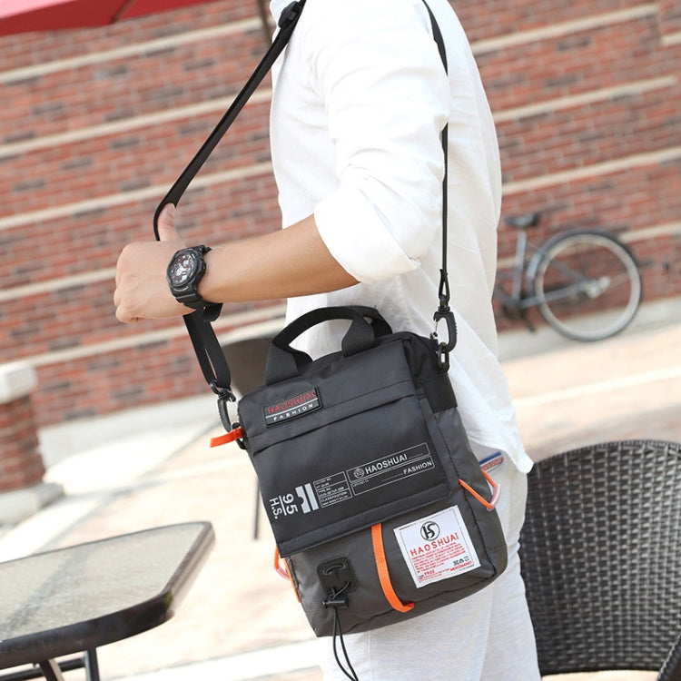 Men's black crossbody bag with adjustable strap, front zip pocket and orange trim