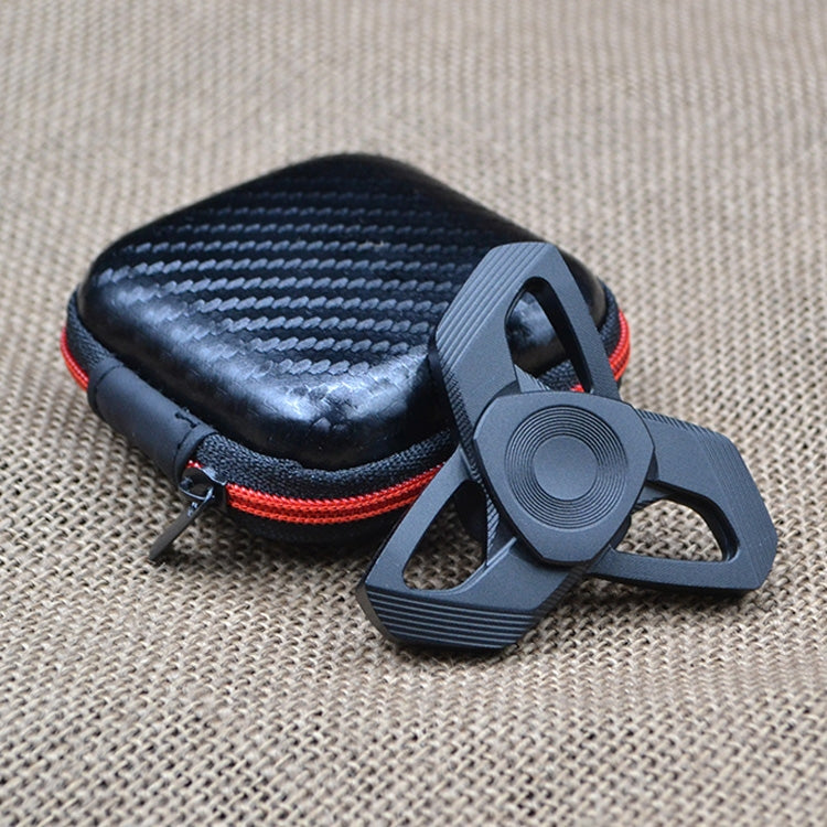 Black metal hand spinner with three arms next to zippered storage pouch