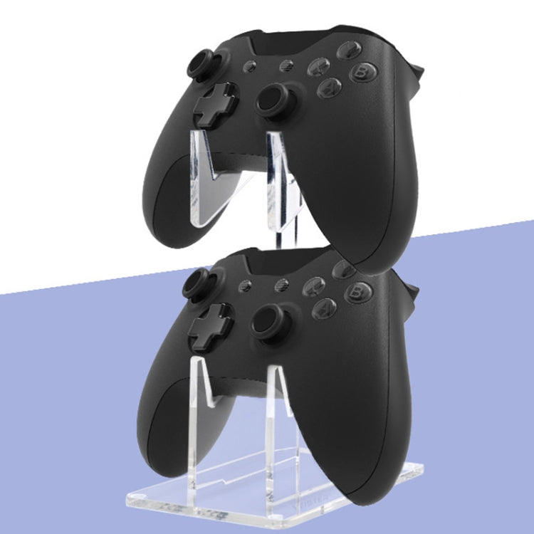 Clear acrylic bracket holding two black controllers in V-shaped slots