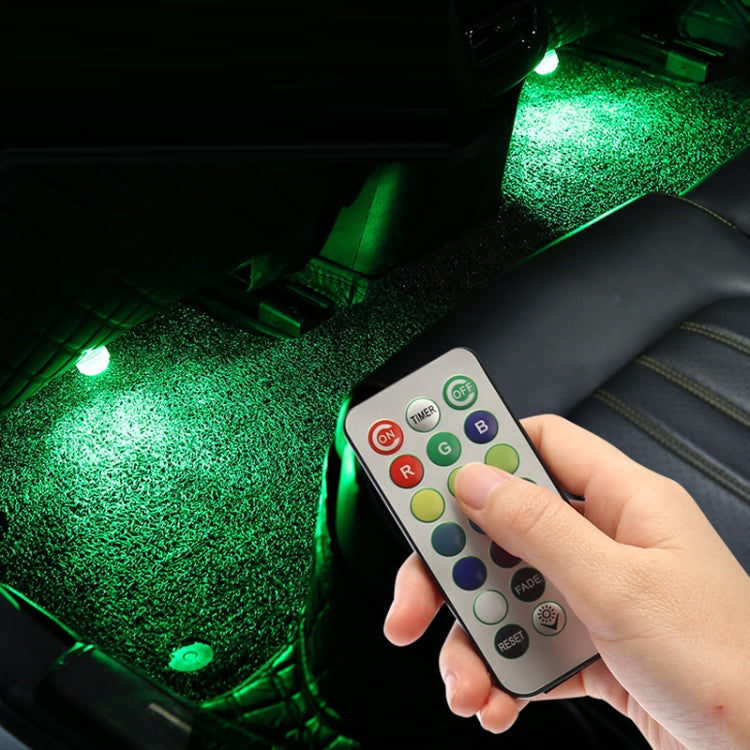 Hand holding remote controlling green LED car atmosphere lights in vehicle interior