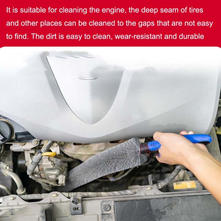 Hand using long car brush with gray bristles and blue handle in engine bay